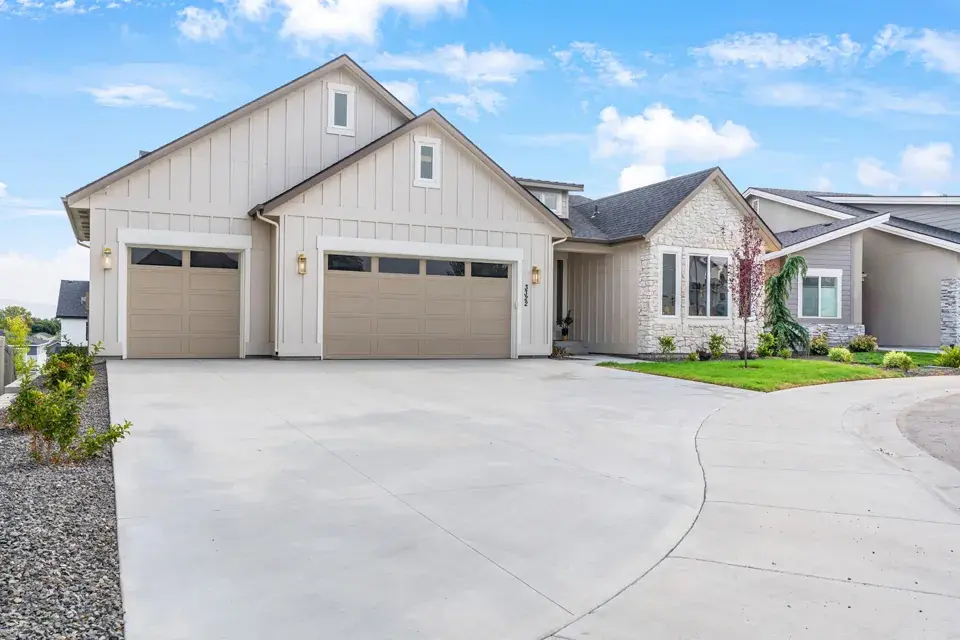 The front of 3322 S Volunteer Place in Meridian, Idaho: a single-level Bear Homes build with board and batten siding, a stone entry and a three car garage