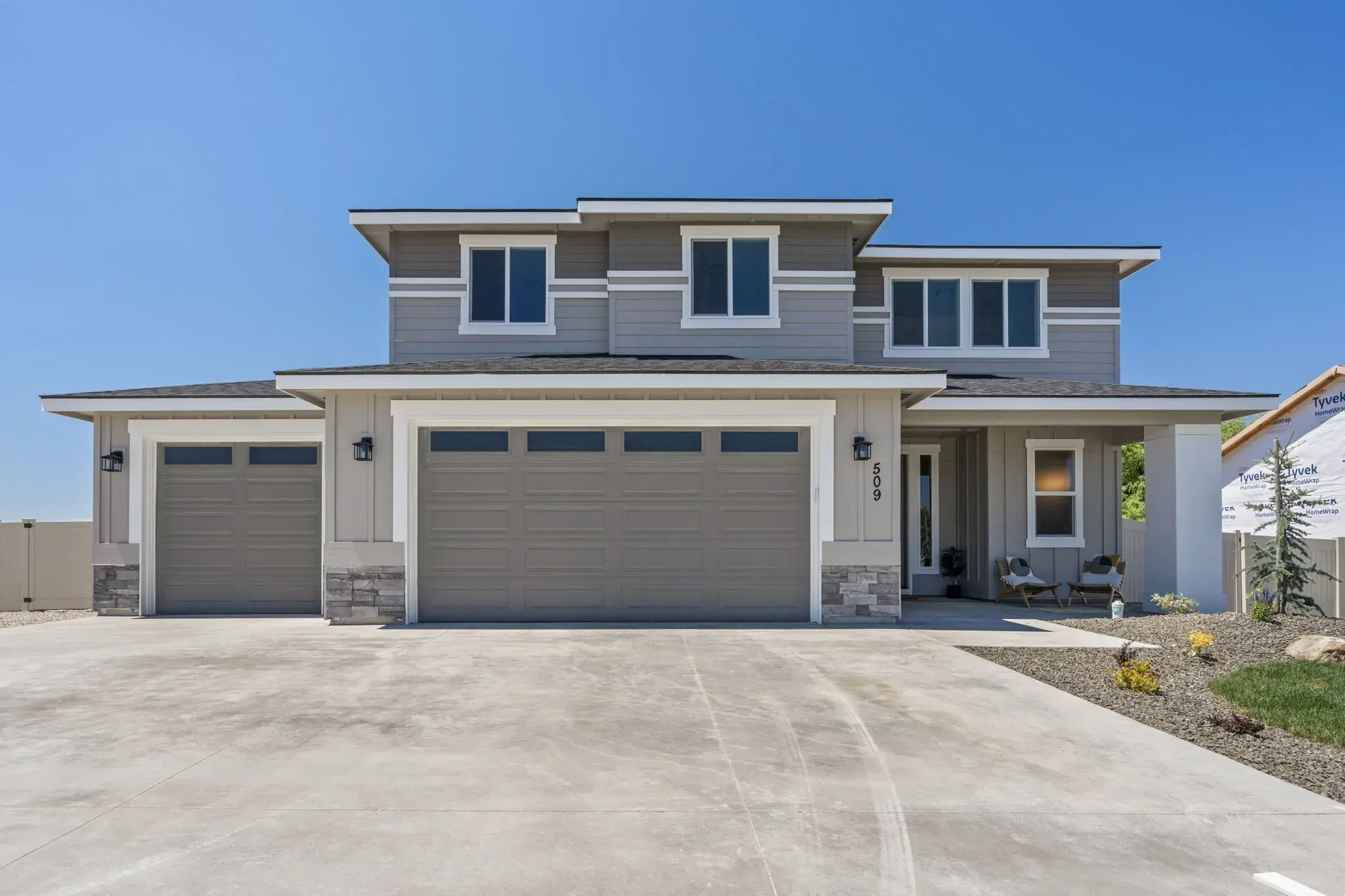The front of 509 Grand Harvest Avenue in New Plymouth, Idaho: a two-story Bear Homes build with a three car garage and stone accents