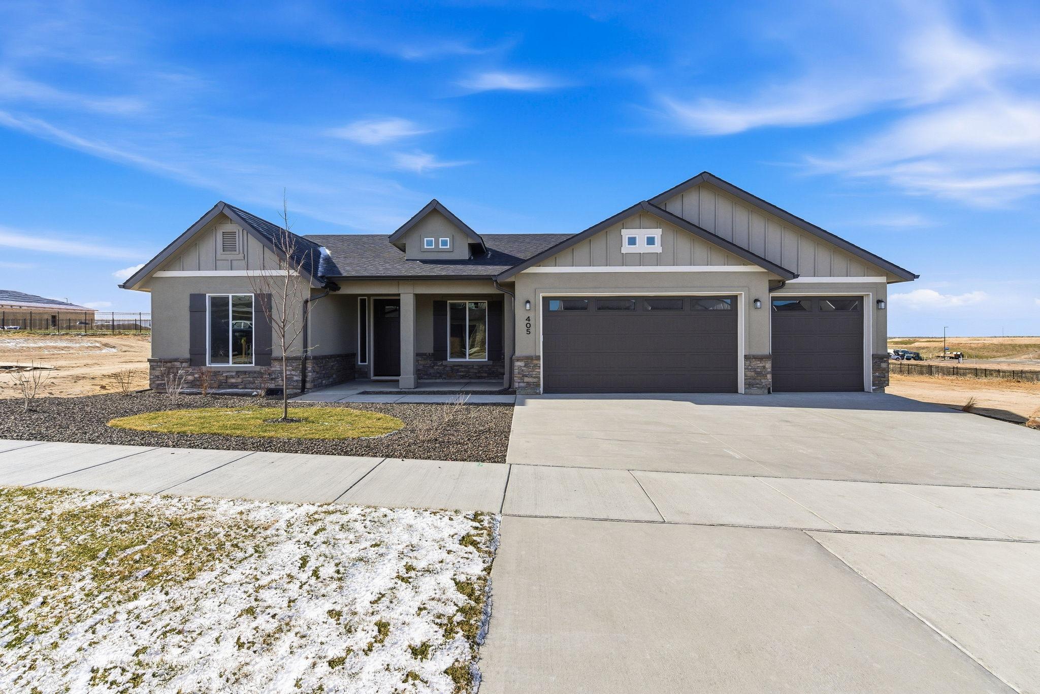 The Alpine in Boise: a single level craftsman with board and batten gables, stone wainscot, and a three car garage